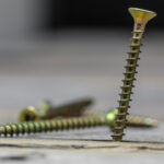many of the screws looks beautiful on wooden background, closeup